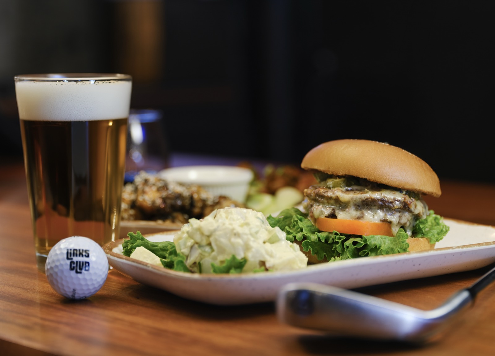 Smash burger with lettuce and tomato, housemade potato salad, and a pint of beer