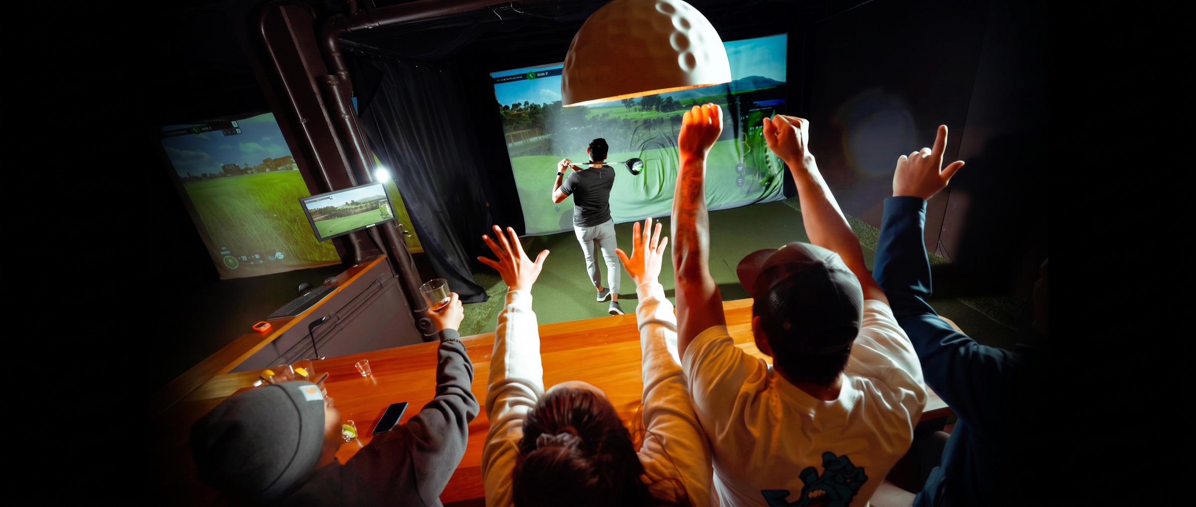 Friends cheering a drive on a TrackMan simulator bay at Links Club